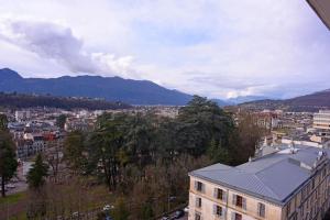 a view of a city with mountains in the background at Studio avec piscine, Vue lac et montagne in Aix-les-Bains