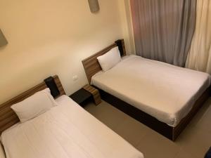 2 camas en una habitación pequeña con sábanas blancas en Mousa Coast Chalets & Villas (Managed By Mousa Coast) en Ras Sedr
