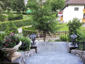 a garden with a stone walkway with flowers in a vase at Haus Kurparkblick in Todtmoos
