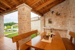 ein Esszimmer mit einem Holztisch und einer Steinmauer in der Unterkunft Villa Milka in Labin