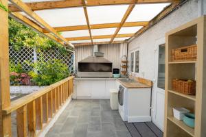 an outdoor kitchen with a wooden pergola at House with Garden & BBQ in Edmonton
