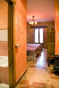 una camera con tavolo e vasca di Hotel Rural El Cañón del Duratón en Villaseca de Sepúlveda a Sepúlveda
