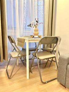 a dining room table with two chairs and a vase on it at Apartment Simona - Old Town in Bratislava