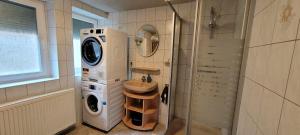 uma casa de banho com uma máquina de lavar roupa e um lavatório em Suhl - Ihre erholsame Wohnung in Zentrumnähe em Suhl