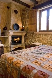 una camera con un grande letto e un camino di Hotel Rural El Cañón del Duratón en Villaseca de Sepúlveda a Sepúlveda