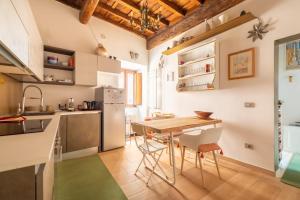 a kitchen and dining room with a table and chairs at Reginella White Apartment in Rome
