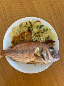a plate of fish and potatoes on a table at Hôtel Restaurant Petra Cinta in Barcaggio