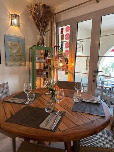 una mesa de madera con copas de vino y servilletas en Hôtel Restaurant Petra Cinta, en Barcaggio