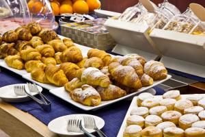a table with several trays of donuts and other pastries at Villa Lovi in Bassano del Grappa