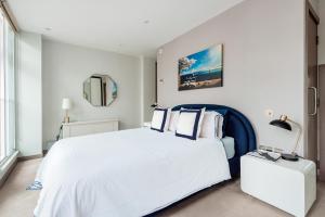 Arcore Premium Apartments: Mayfair في لندن: غرفة نوم بسرير ابيض كبير ومرآة