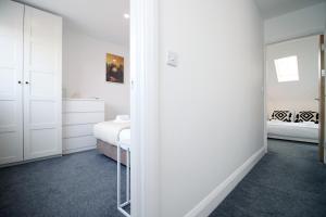 biały pokój z łóżkiem i lustrem w obiekcie Charming 2BR Cardiff Oasis with Private Courtyard w Cardiff
