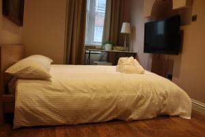 uma cama com lençóis brancos e almofadas num quarto em Modern 2 Bedroom Apartment Notting Hill Gate/Kensington em Londres