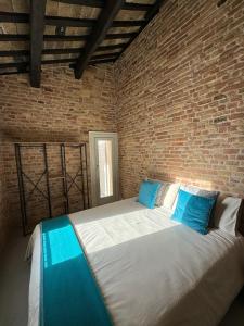 a bedroom with a large bed in a brick wall at Noua Luxury Studio Apartments in Ravenna