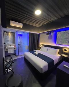 a bedroom with a large bed with blue lights at B Hotel Kuala Lumpur in Kuala Lumpur