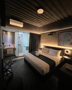 a bedroom with a large bed and a bathroom at B Hotel Kuala Lumpur in Kuala Lumpur