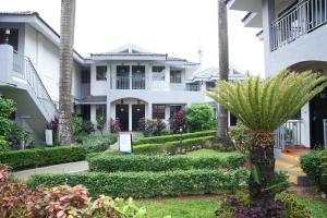 a garden in front of a white building at Baywatch Resort, Colva Goa in Colva