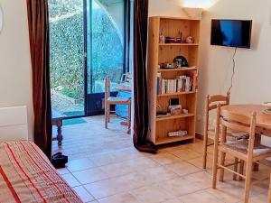 ein Wohnzimmer mit einem Tisch und einem TV sowie ein Zimmer mit einem Fenster in der Unterkunft Appartement Bormes-les-Mimosas, 2 pièces, 4 personnes - FR-1-610-97 in Bormes-les-Mimosas