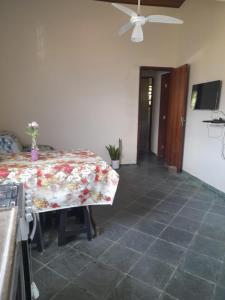 uma sala de jantar com uma mesa com uma toalha de mesa floral em Casa praia da enseada em Ubatuba em Ubatuba