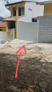 une flèche rouge est tirée dans une allée. dans l'établissement Casa praia da enseada em Ubatuba, à Ubatuba
