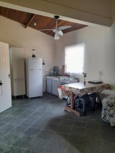 a kitchen with a refrigerator and a table in it at Casa praia da enseada em Ubatuba in Ubatuba
