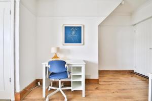 StayRight Homely 3 Bedroom House in Vibrant Whitchurch في كارديف: كرسي أزرق جالس في مكتب في الغرفة