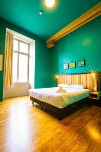 um quarto verde com uma cama e piso em madeira em The People - Strasbourg em Estrasburgo