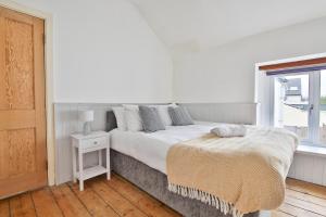 Habitación blanca con cama y ventana en StayRight Homely 3 Bedroom House in Vibrant Whitchurch, en Cardiff