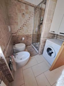 uma casa de banho com um WC e uma máquina de lavar roupa em Casa Marzia&Daniele em Roma