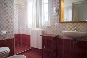 a bathroom with a sink and a toilet and a mirror at La Vineria di San Mattia in Verona