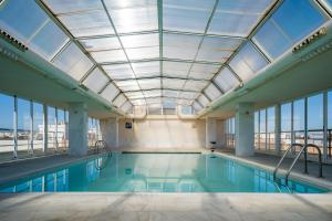 a swimming pool with a skylight in a building at Hotel Bartos in Almussafes