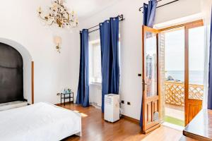 a bedroom with a bed and a balcony with the ocean at Isola Bella - Rooms il Pescatore in Taormina