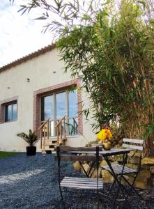 a house with a picnic table in front of it at Maison avec hammam privé en option - Maison Mandala in Legé