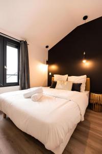 Cette chambre comprend un grand lit blanc et une fenêtre. dans l'établissement Eldorado - Résidence Hestia, à Saint-Étienne