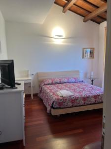 a bedroom with a bed and a tv in it at Podere Baratta agriturismo e cantina in Collinello