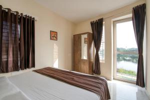 a bedroom with a bed and a large window at Aafiya lakeview Apartments in Coimbatore