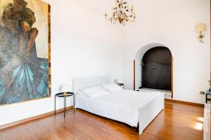 タオルミーナにあるIsola Bella - Rooms il Pescatoreの白いベッドと壁に絵画が飾られたベッドルーム1室