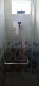La salle de bains est pourvue d'une douche avec des arbres sur le mur. dans l'établissement Bana Home & Spa, à Hội An