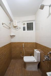 a bathroom with a toilet and a window at Aafiya lakeview Apartments in Coimbatore