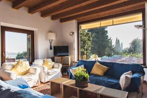 a living room with blue couches and a large window at La Vineria di San Mattia in Verona
