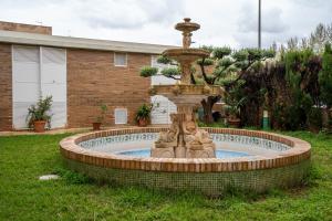 einen Brunnen in der Mitte eines Gartens in der Unterkunft Hotel Bartos in Almussafes