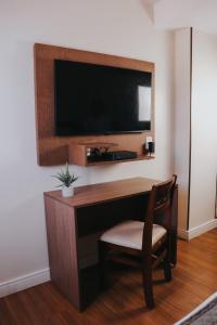 Habitación con escritorio, TV y silla. en Vida Plaza Hotel, en Brasilia