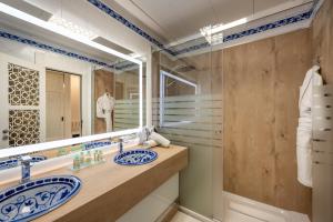 un bagno con due lavandini e un grande specchio di Hotel Saray a Granada