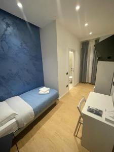 1 dormitorio con cama y pared azul en B&B Grace's Home Affittacamere, en Canicattì