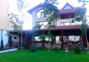 a house with a green lawn in front of it at Todorovi Guest House in Stara Zagora