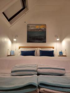 ein Schlafzimmer mit einem großen Bett mit blauen Kissen in der Unterkunft Host & Stay - Clara Cottage in Bretforton