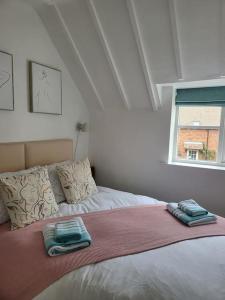 a bedroom with a bed with two folded towels on it at Guest Homes - Clara Cottage in Bretforton