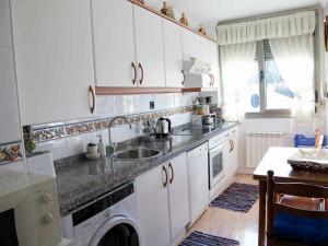 a kitchen with a sink and a washing machine at Duplex Garonda in Pravia