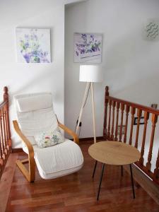 ein Wohnzimmer mit einem Stuhl und einer Lampe in der Unterkunft Duplex Garonda in Pravia