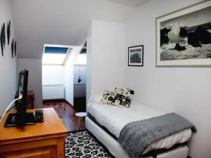 a bedroom with a bed and a desk with a computer at Duplex Garonda in Pravia