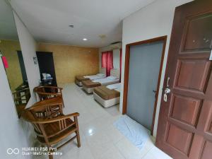 een woonkamer met een deur en een bank en stoelen bij Marang Village Resort in Marang